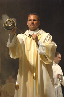 Deacon Eric Nagel incenses the priests during the chrism Mass on April 3 at SS. Peter and Paul Cathedral in Indianapolis. He believes his family’s support and several miracles led him to say “Yes” to God’s call to the priesthood. (Photo by Sean Gallagher) 