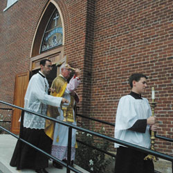 Priestly Fraternity of St. Peter Father Gerard Saguto elevates the host at the solemn Mass celebrated on Sept. 6 at SS. Philomena and Cecilia Church in Oak Forest after archdiocesan vicar general Msgr. Joseph F. Schaedel solemnly blessed the church. Father Saguto is being assisted by Priestly Fraternity of St. Peter Father Mark Wojdelski and Priestly Fraternity of St. Peter Father Father Michael Magiera.