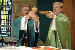 Deacon Michael Stratman, left, assists Father Rick Ginther during an Aug. 9 Mass at St. Margaret Mary Church in Terre Haute. Ordained on June 28, 2008, as a member of the first class of permanent deacons in the history of the Archdiocese of Indianapolis, Deacon Stratman ministers at St. Margaret Mary and St. Patrick parishes in Terre Haute, where Father Ginther serves as pastor. (Photo by Sean Gallagher) 