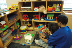 Two brothers who will temporarily reside at the new Holy Family Shelter in Indianapolis with their parents and siblings enjoy play time together in the children’s day care center during a Dec. 6 open house. (Photo by Mary Ann Wyand)