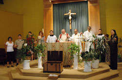 During Mass on the feast of the Body and Blood of Christ on June 6, Father Larry Crawford, the pastor of St. Gabriel the Archangel Parish in Indianapolis since 1999, prays the Lord’s Prayer with Deacon Oscar Morales, the pastoral associate, and parishioners. The liturgy marked the final celebration of the Eucharist before the start of the $508,000 church renovation project, which will transform the interior during the next six months. (Photo by Mary Ann Wyand)