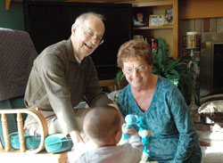 Jay and Lois Peterson focus their attention on the latest of the 37 foster children they have welcomed into their home during the past 28 years. The Petersons, members of St. Christopher Parish in Indianapolis, are also the parents of seven children, including one child they adopted. (Photo by John Shaughnessy)