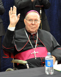 Archbishop Daniel M. Buechlein acknowledges the standing ovation that he received from priests, friends, archdiocesan employees and members of the media at the Archbishop Edward T. O’Meara Catholic Center in Indianapolis on Sept. 21 after it was announced that he is retiring as shepherd of the Archdiocese of Indianapolis. (Photo by Mary Ann Garber)