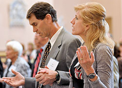 Mike and Melissa Gossman of St. Malachy Parish in Brownsburg hold hands during the Our Father at the Miter Society Mass at SS. Peter and Paul Cathedral on May 1. (Photo by Natalie Hoefer)