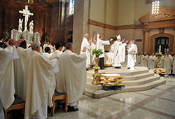 More than 130 priests who minister in central and southern Indiana join Archbishop Joseph W. Tobin in blessing chrism oil during the annual archdiocesan chrism Mass celebrated on March 31 at SS. Peter and Paul Cathedral in Indianapolis. The Mass featured the blessing of holy oils used in several sacraments and in the dedication of altars and church buildings. During the Mass, the priests also renewed their ordination promises. (Photo by Sean Gallagher)