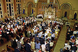 Worshipers hold candles at the start of the Easter Vigil on April 16 at Our Lady of the Most Holy Rosary Church in Indianapolis. (Photo by Sean Gallagher)