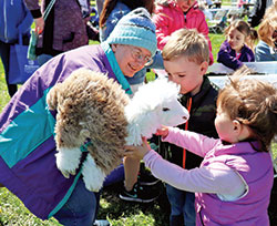 Providence Sister Patty Wallace meets with two children on April 28, 2018, during an Earth Day event. (Submitted photo)