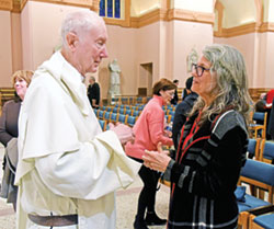 Karla Hudacek, pastoral associate and director of religious education at St. Thomas Aquinas Parish in Indianapolis, speaks on Dec. 6 with Dominican Father Timothy Radcliffe in SS. Peter and Paul Cathedral in Indianapolis after the priest gave a presentation on the recent meeting of the Synod of Bishops on synodality. (Photo by Sean Gallagher)