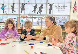 Emily Schuler, the principal of St. Patrick School in Terre Haute, helps students from kindergarten and first grade with an art project. (Photo courtesy of Kelli Carney, first-grade teacher at St. Patrick School)