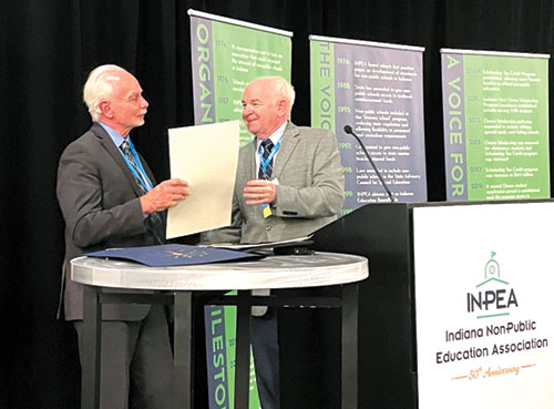 John Elcesser, left, executive director of the Indiana Non-Public Education Association (INPEA), receives the Sagamore of the Wabash award on Sept. 26 at an event marking the 50th anniversary of the INPEA. His INPEA predecessor Glenn Tebbe, himself a Sagamore recipient, presented the state award to his longtime colleague and friend. (Photos by Andrea Anderson)