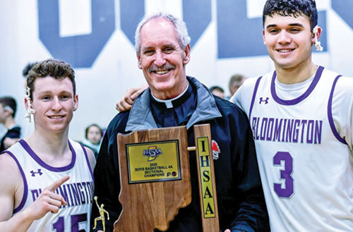 Father Thomas Kovatch poses with Noah Jager, left, and Anthony Leal, both members of St. Charles Borromeo Parish in Bloomington, at Columbus North High School in Columbus in March 2020 after Jager’s and Leal’s Bloomington South High School boys basketball team won its sectional in the Indiana High School Athletic Association boys basketball tournament. (Submitted photo).