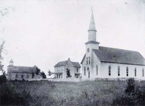 This undated photo depicts two St. Bernard Parish church structures in Frenchtown. The church at left, built in 1881, was damaged by lightning in 1886. The structure at right, built in 1894, is the parish’s current church, although the steeple has since been shortened and a connected parish hall has been added. Between the two churches is the former rectory. (Submitted photo)