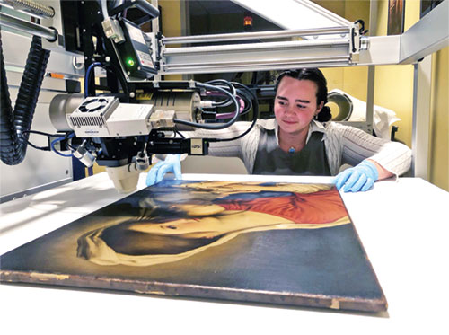 Allie Miller, a senior at Marian University in Indianapolis, uses an X-ray fluorescence macro-scanner in analyzing the painting Madonna and Child in the collection of the Indianapolis Museum of Art at Newfields during an internship there this past summer. The United States Postal Service selected the painting as an image for one of its Christmas stamps this year. (Submitted photo)