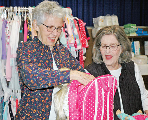 Marilyn Webb, left, and Helen Burke, volunteers at the archdiocesan Catholic Charities’ Christmas Store in Indianapolis, show their delight at the donation of a doll, knowing it will make a child’s Christmas special. (Photo by John Shaughnessy)